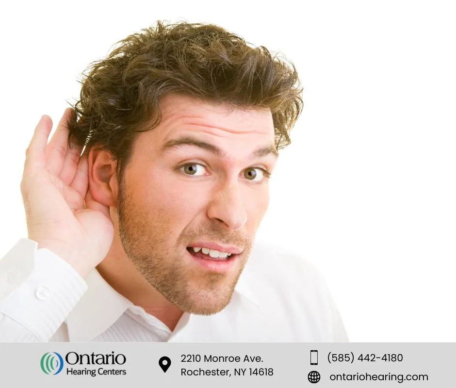 Man cupping his ear to listen, representing earwax-related hearing loss