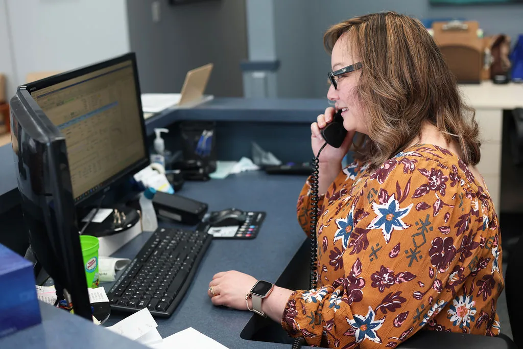 Woman on phone at office desk with computer