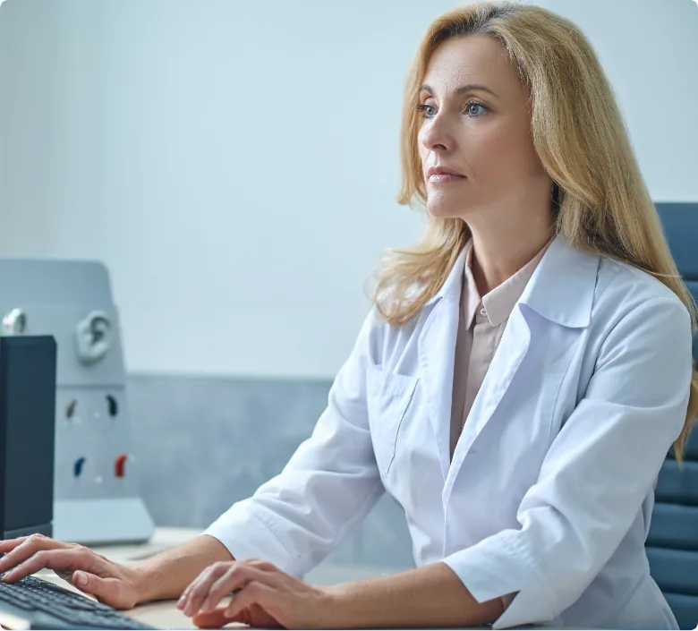 Female healthcare professional typing at computer desk