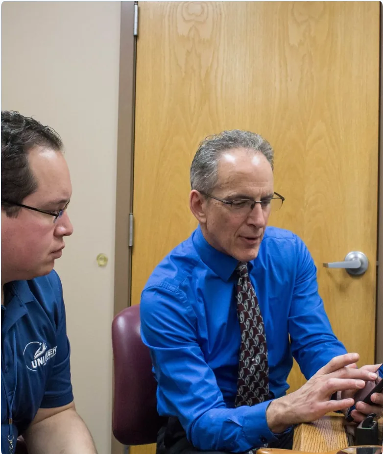 Two men in consultation discussing hearing device