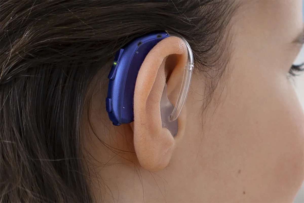 Oticon Xceed Play blue hearing aid worn on ear