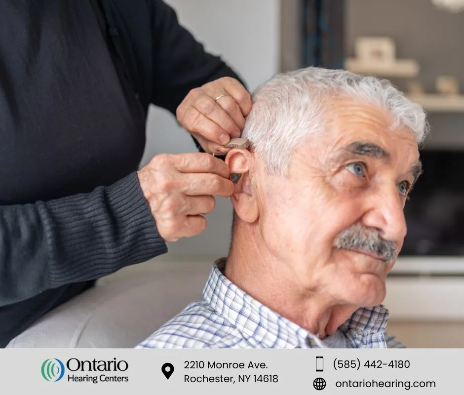 Hearing aid being fitted for an older male patient