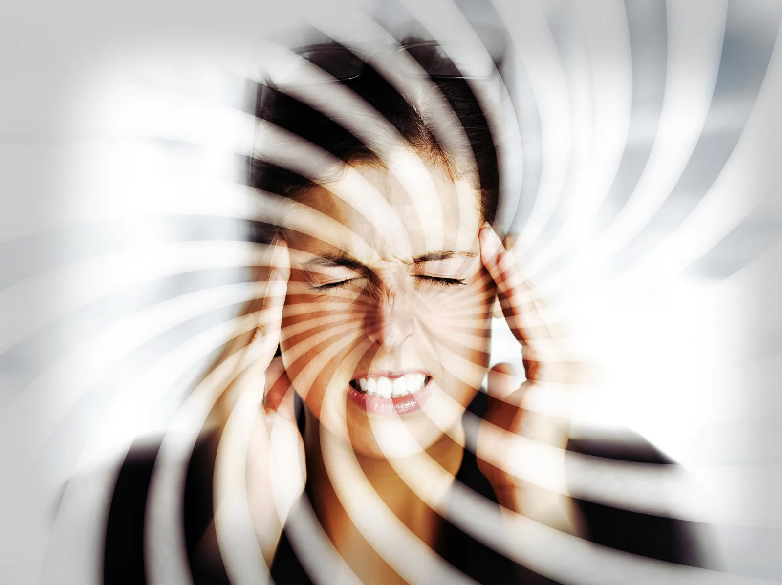 Person holding temples with spiral blur effect showing dizziness