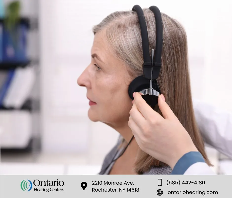 Woman having audiometry headphones placed during hearing test