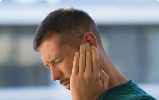 Man with ear pain holding hand to right ear